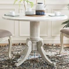 a white table with two chairs around it