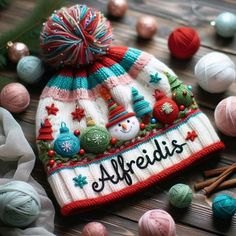 a knitted hat with the word affridis written on it next to balls of yarn