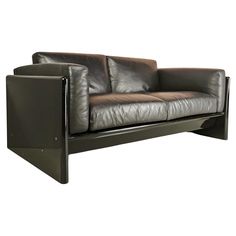 a brown leather couch sitting on top of a metal frame