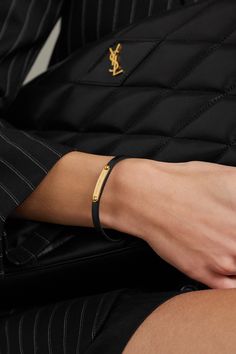 SAINT LAURENT's bracelet is crafted from leather and embellished with an engraved gold-tone ID bar. Match your earrings to the hardware or gift it to someone special. Elegant Leather Bracelet With Gold Clasp, Luxury Leather Bracelet With Gold-tone Hardware, Classic Yellow Gold Leather Bracelet, Modern Gold Leather Bracelet With Gold-tone Hardware, Formal Gold Leather Bracelet With Gold-tone Hardware, Luxury Leather Bracelet With Gold Clasp, Elegant Leather Bracelets With Gold-tone Hardware, Gold Leather Bracelets With Gold-tone Hardware, Elegant Leather Bracelets With Gold Clasp