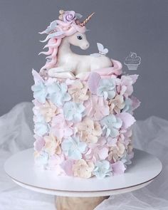 there is a cake decorated with flowers and a unicorn on top