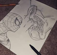 a drawing of a spiderman and a man's face on paper with pencils