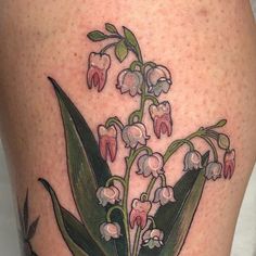 a close up of a tattoo with flowers on the side of a woman's leg