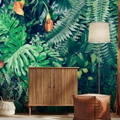 a tropical wallpaper with orange flowers and green leaves in the background, next to a rattan sideboard