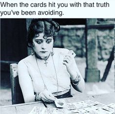 a woman sitting at a table with cards in front of her and the caption reads, when the cards hit you with that truth you've been avoiding