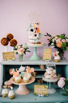 a table topped with lots of cakes and cupcakes