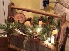 a wooden crate filled with pine cones and candles