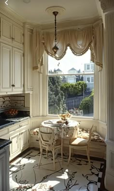 a kitchen with a table and chairs in front of a window that looks out onto the yard