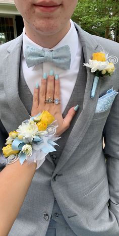 a man in a suit and tie with flowers on his lapel is holding the woman's hand