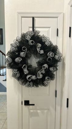 a black and white wreath hanging on the front door