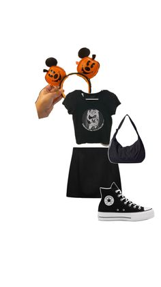 someone is holding up their hand to show off her halloween outfit and shoes, which are also decorated with pumpkins