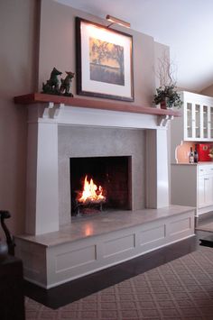 a living room with a fire place in the center and cabinets on either side of the fireplace