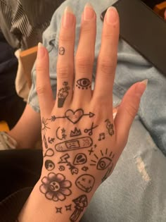 a woman's hand with tattoos on it and other things drawn on her fingers