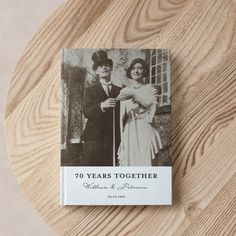 a book with an image of two people standing next to each other on top of a wooden table