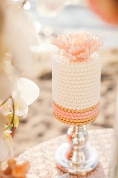 a white and pink wedding cake on a table