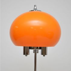 an orange table lamp on a metal base