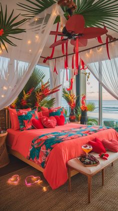 a bedroom with an ocean view is decorated in coral and turquoise colors, along with palm leaves