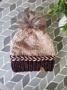 This hat is super fun because its a beige/brown combo and a lightpink/dark purple color depending on the light! chunky yarn that will keep your head warm in the winter!  Size medium approximately 21" will stretch with normal wear. Please measure your head circumference before ordering. Measures 9" tall before pom. 100% merino wool  Care instructions- hand wash perfered. May wash in garment bag on delicate/cold. Lay flat to dry. DO NOT WASH POM- pom is removable  Patern is Tidal Crest Beanie by Little Lakespur Design. You could make your own! Warm Brown Hat One Size Fits Most, Hand Knitted Beige Hat For Fall, Brown Knitted Hat For Fall, Brown Knitted Hat One Size Fits Most, Warm Brown Hat, One Size Fits Most, Purple Hat For Fall, Brown Brimmed Hat For Cold Weather, Beige Hand Knitted Hats For Fall, Brown Knitted Casual Beanie