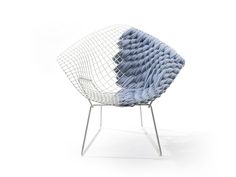 a white chair with blue cushions on it's back and legs, sitting in front of a white background