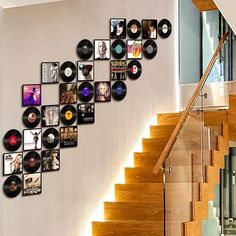 there are many records on the wall next to the stair case in this house that is decorated with vinyl record art