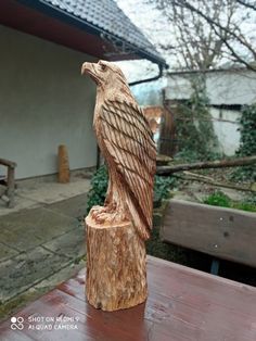 a carved wooden bird sitting on top of a table