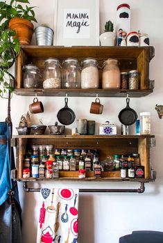 an old wooden shelf filled with spices and other kitchen items next to a potted plant