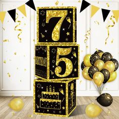 a black and gold number five birthday cake surrounded by balloons, streamers and confetti