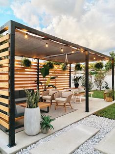 a covered patio with seating and potted plants