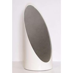 a white object with a grey circle on it's side, sitting on a table