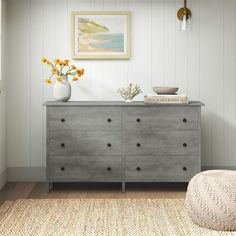 a gray dresser in a white room with yellow flowers