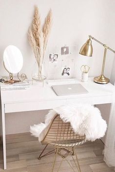 a white desk topped with a laptop computer sitting next to a chair and lamp on top of a hard wood floor