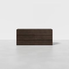 a brown dresser sitting on top of a white floor