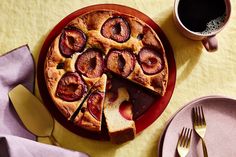 a pie with slices cut out on a red plate next to a cup of coffee