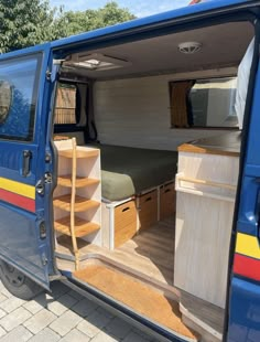 the interior of a blue van with its doors open and shelves in place for storage