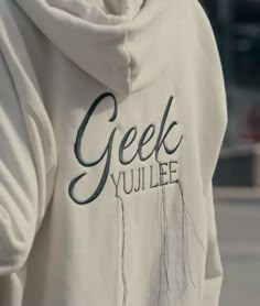 a person wearing a white hoodie with the words geek you lee on it's back