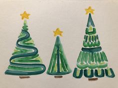 three watercolor christmas trees on white paper