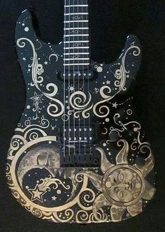 a black and white guitar with intricate designs on it's body, sitting on a black background