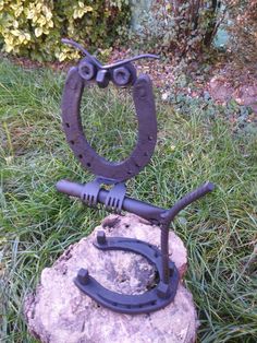 a metal object sitting on top of a rock in the grass