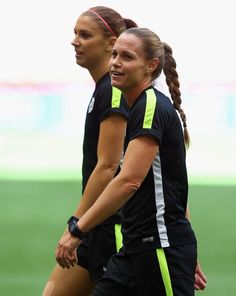 two female soccer players are walking on the field