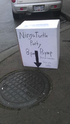 a box that has been placed on the ground next to a manhole cover with a sign saying ninja turtle party 8pm pyrop