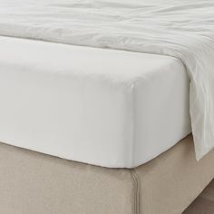 a close up view of a bed with white sheets