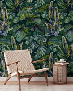 a chair and table in front of a wallpapered with green leaves on it