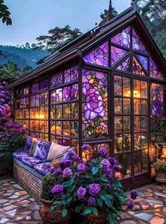 a glass house with purple flowers in it