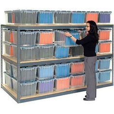 a woman standing in front of a shelf filled with plastic bins