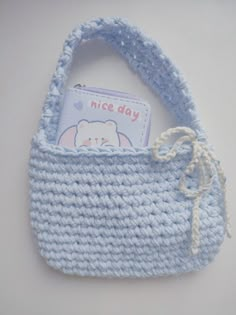 a blue crocheted purse with a card in it