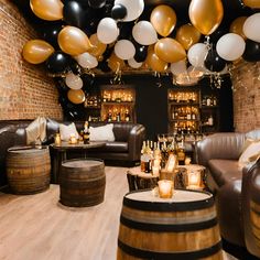 a room filled with lots of balloons and wine barrels on the floor next to couches