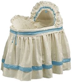 a white crib with blue trim and ruffles on the bottom, sitting in front of a white background