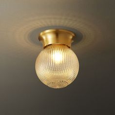 a light that is on the ceiling with a glass ball hanging from it's side