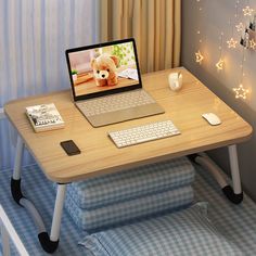 a laptop computer sitting on top of a wooden desk