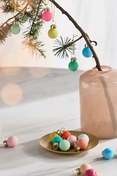 a vase filled with ornaments sitting on top of a table next to a small plate